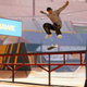An image from Tony Hawk's Pro Skater 1 + 2 depicting a skateboarder doing a kickflip over a handrail at Tony Hawk's Birdhouse skatepark.